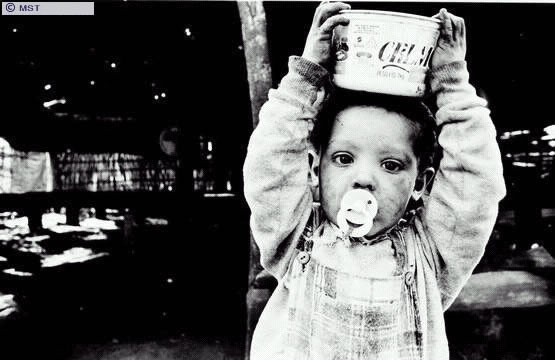 Criança carregando água no acampamento Oziel Alves Pereira, na  ...